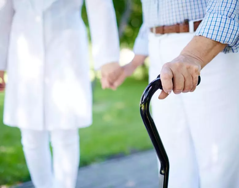 A person gets assistance walking with a cane