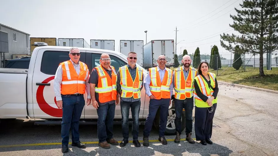A group of Veolia employees stands in a facility smiling at the camera